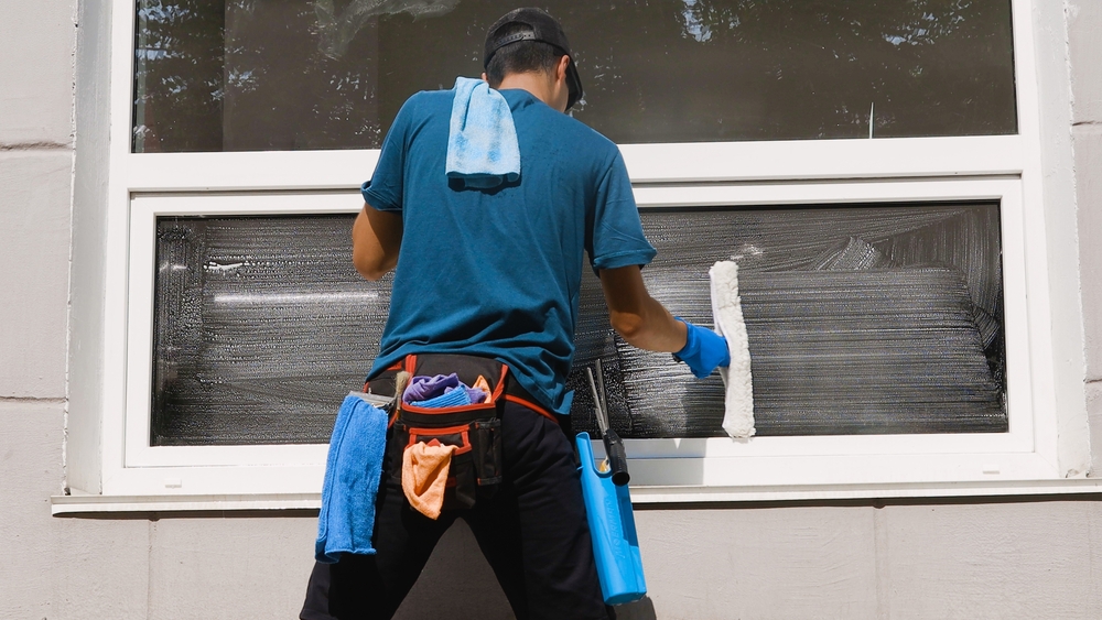 Window cleaner washing exterior glass on a Ponca City home